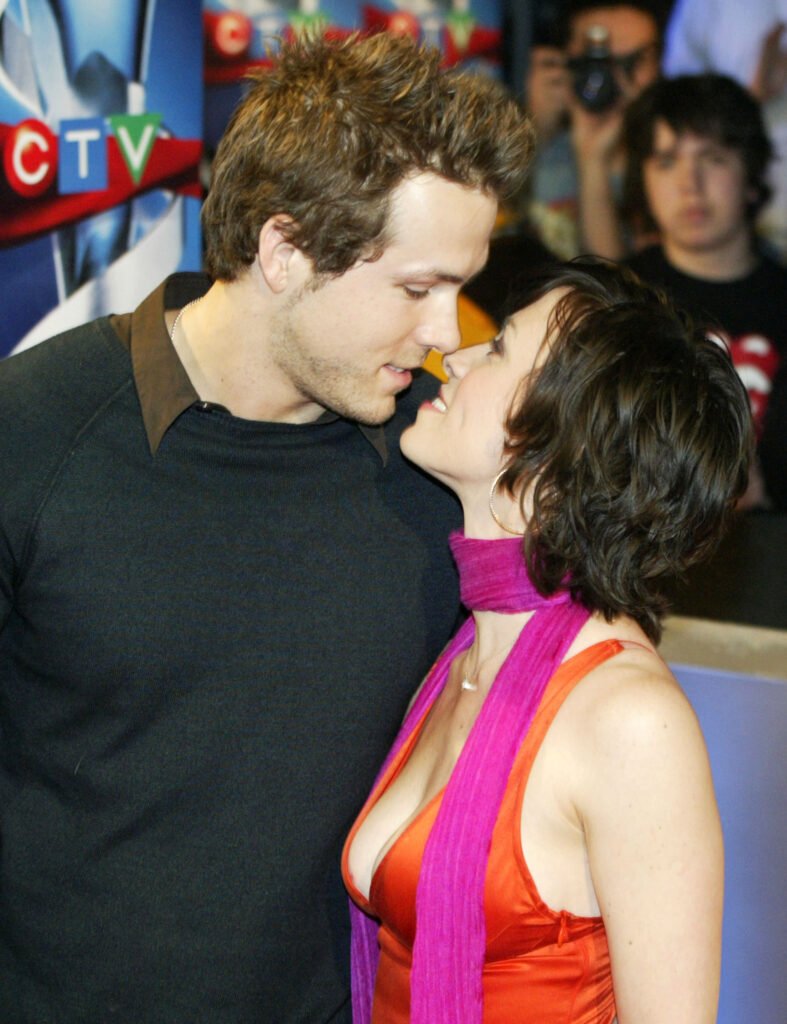 Ryan Reynolds (L) and Alanis Morissette lean in for a kiss at a movie premiere