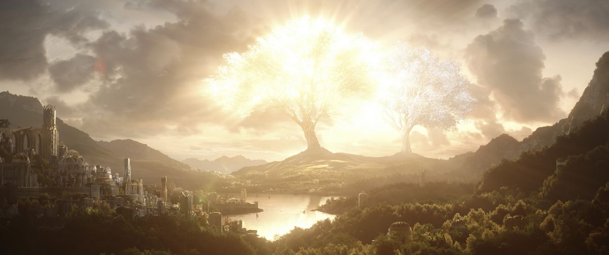 A great elven city in Valinor, with a view of two absolutely massive trees across a lake from the buildings. One glows brightly with gold light, the other is a dimmer silver. From The Lord of the Rings: The Rings of Power.