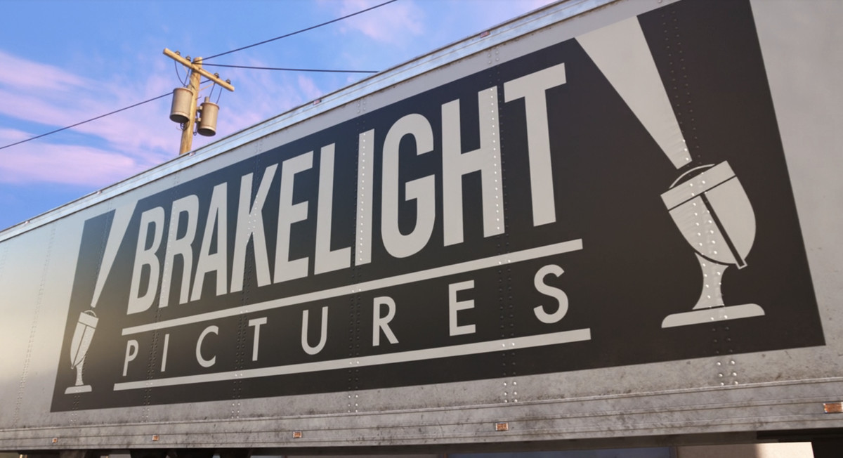 the studio logo of “brakelight pictures”, which is white text on a black box, with drawings of lights on either side