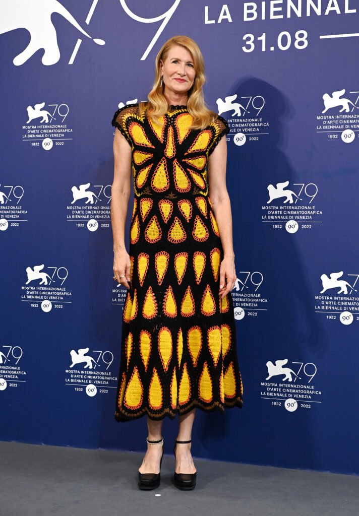 Laura Dern poses in black knit dress with large yellow teardrop patterns