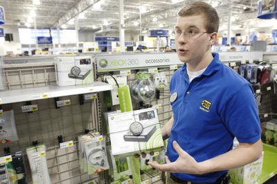 Best Buy home theater rep shown in 2008 photo holding an Xbox 360 HD-DVD add-on drive.
