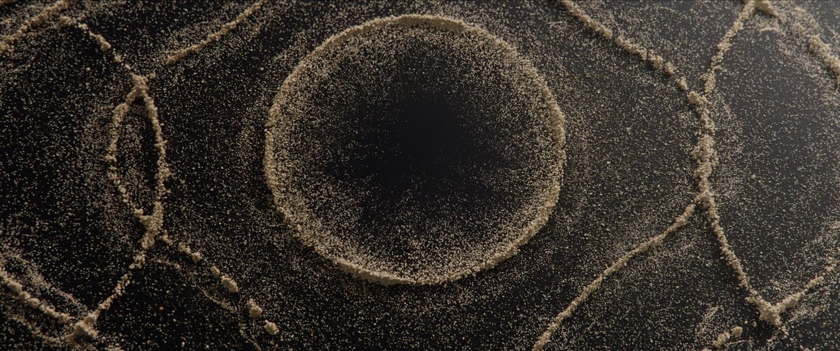 A close-up shot of a sand bending and forming into circular patterns.