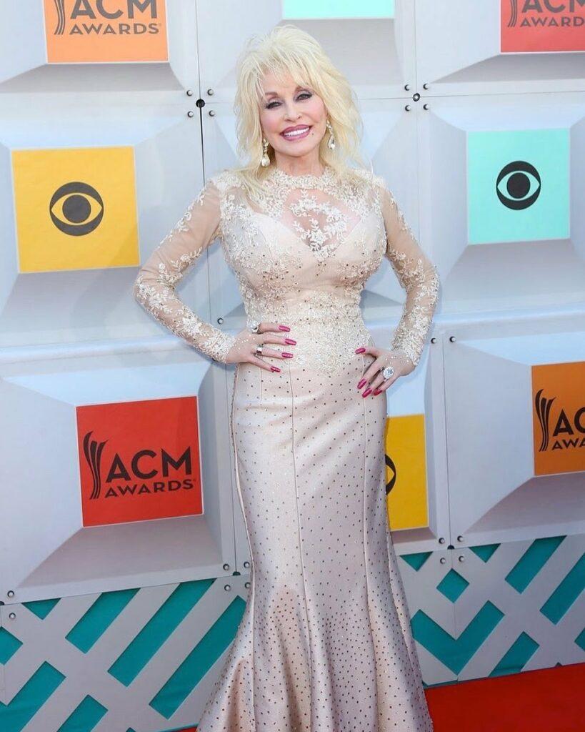 A photo showing Dolly Parton in a shiny dress with a big smile on her face