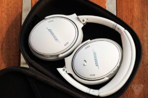 A pair of Bose’s comfortable QuietComfort 45 headphones in their case sitting on a bench.