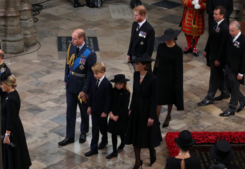LONDON, ENGLAND - SEPTEMBER 19: Prince William, Prince of Wales, Prince George of Wales, Princess Charlotte of Wales, Catherine, Princess of Wales, Prince Harry, Duke of Sussex and Meghan, Duchess of Sussex follow the coffin of Queen Elizabeth II during the State Funeral of Queen Elizabeth II at Westminster Abbey on September 19, 2022 in London, England.  Elizabeth Alexandra Mary Windsor was born in Bruton Street, Mayfair, London on 21 April 1926. She married Prince Philip in 1947 and ascended the throne of the United Kingdom and Commonwealth on 6 February 1952 after the death of her Father, King George VI. Queen Elizabeth II died at Balmoral Castle in Scotland on September 8, 2022, and is succeeded by her eldest son, King Charles III. (Photo by Phil Noble - WPA Pool/Getty Images)