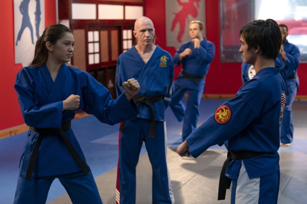 Cobra Kai. (L to R) Oona O'Brien as Devon, Spence Maughon as Sensei Rosenthal in Cobra Kai. Cr. Curtis Bonds Baker/Netflix © 2022