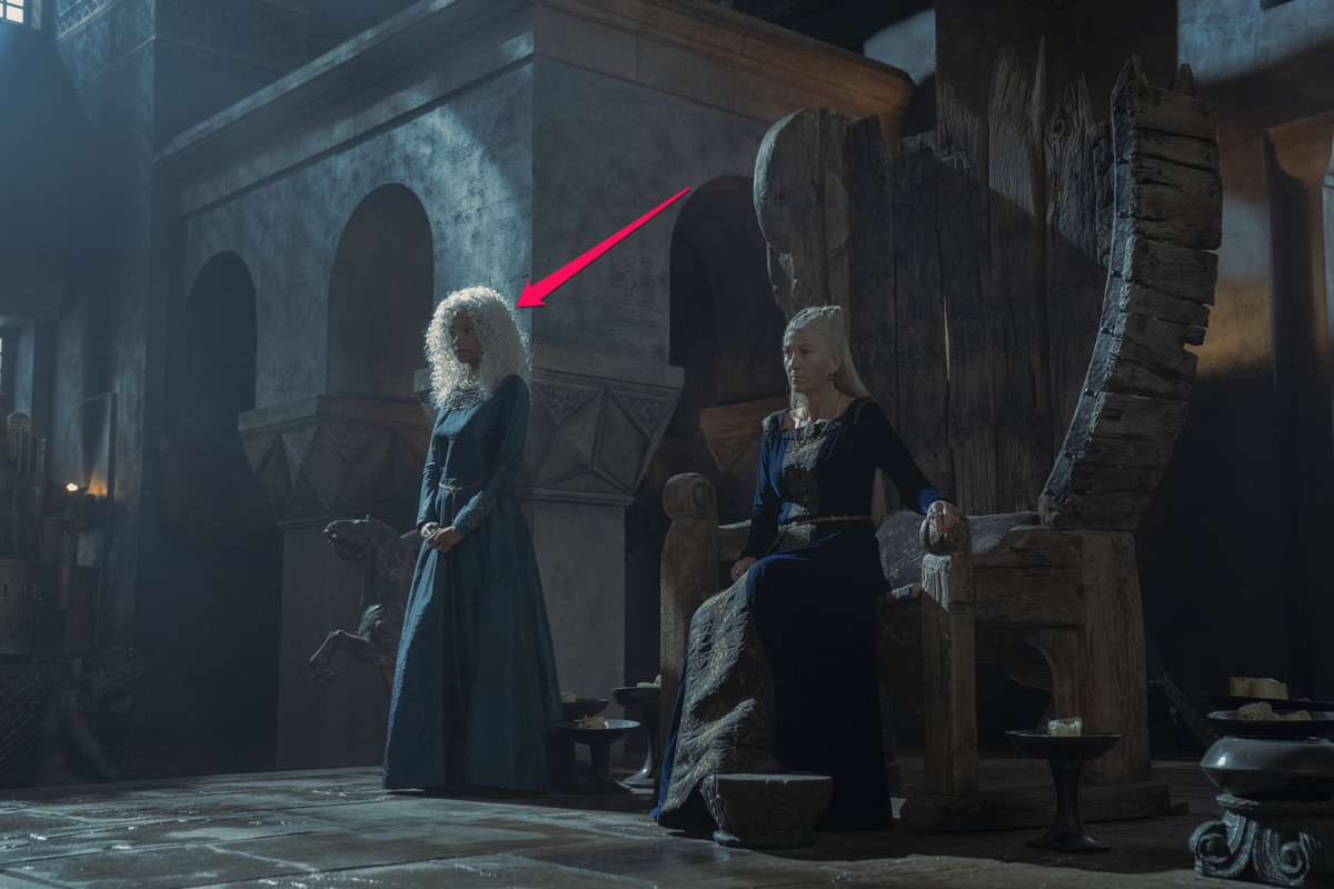 Baela Targaryen (Bethany Antonia) stands next to the throne at Driftmark where Rhaenys Targaryen sits