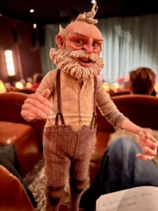 The puppet for Geppetto, an old man, in Guillermo del Toro’s Pinocchio. The author is holding it in a dimly lit screening room