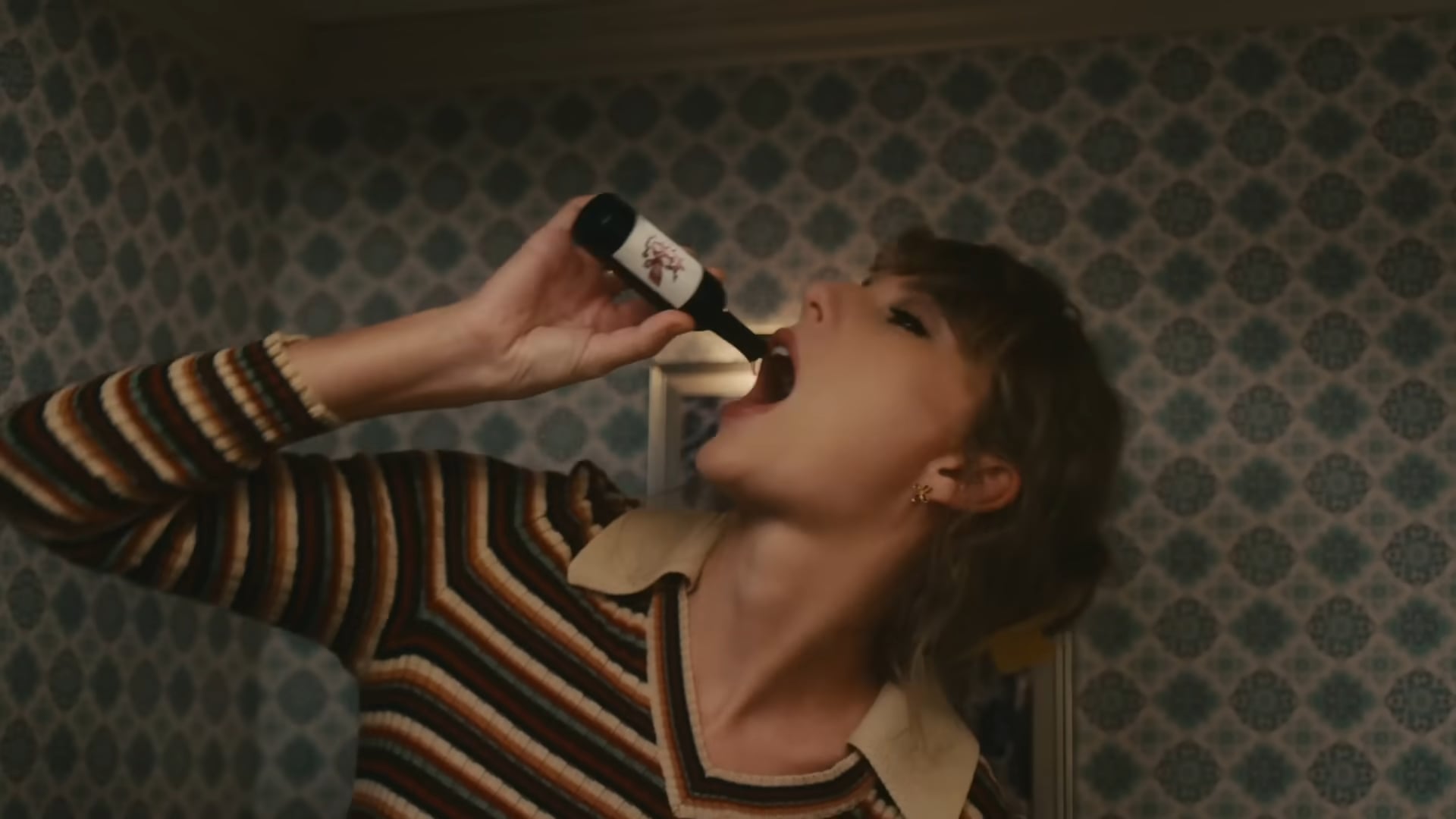 Giant Taylor Swift drinking from a tiny wine bottle