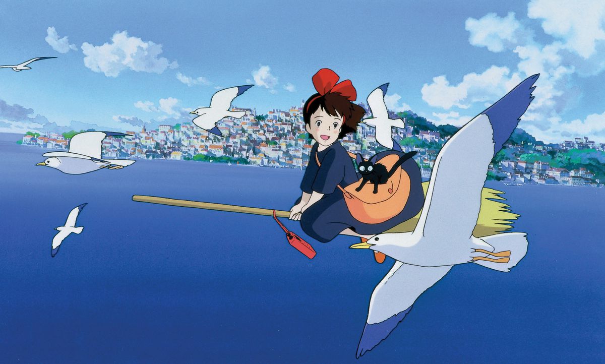 Kiki flying her broomstick over the sea in the animated movie Kiki’s Delivery Service.