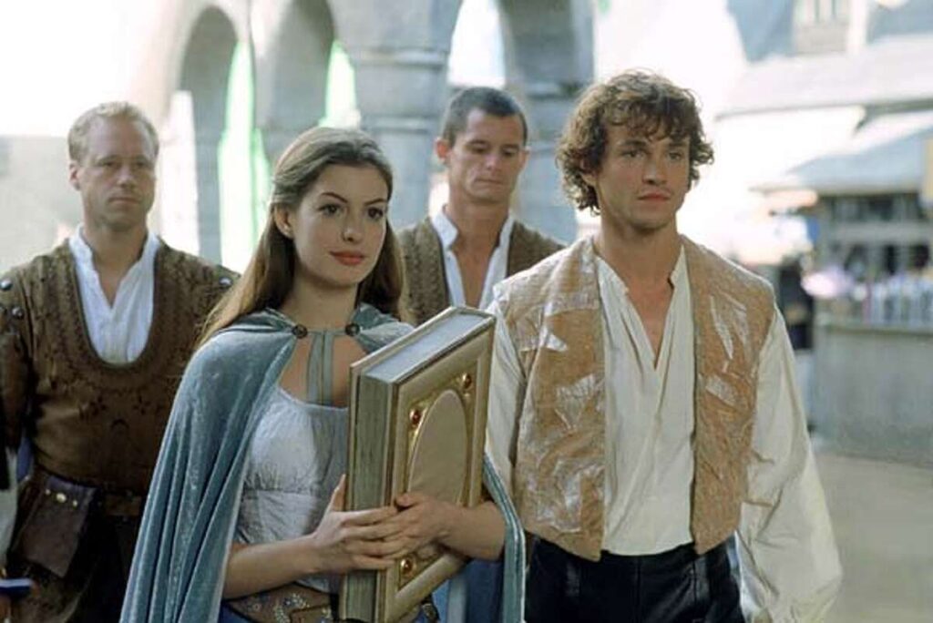 Ella (Anne Hathaway) holding a book beside Prince Charmont (Hugh Dancy) in Ella Enchanted.