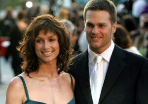 Bridget Moynahan (L) in emerald green dress standing next to Tom Brady, who is wearing a white shirt and tie with a black suit jacket