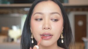 Michelle Phan applying lip gloss in a video posted to her YouTube channel on October 15, 2022