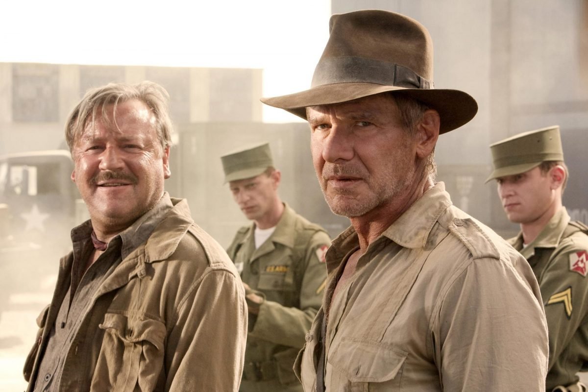 Indiana Jones looks off camera surrounded by soldiers in Indiana Jones and the Kingdom of the Crystal Skull