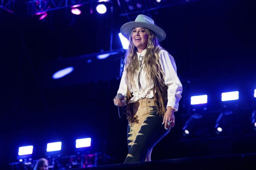 A woman wearing a wide-brimmed hat on stage