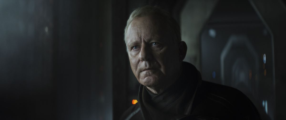 Luthen Rael (Stellan Skarsgard) with a serious look and a black coat in Andor.