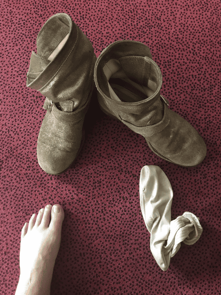 Slouchy, sand-coloured suede boots, one sock and one bare foot