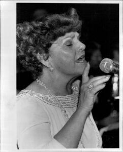 Louise Tobin (pictured) singing at an event in 1984