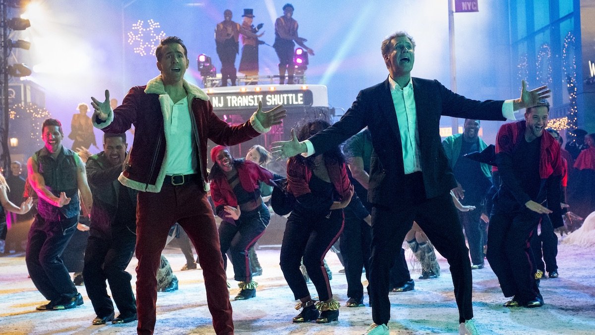 Ryan Reynolds and WIll Ferrell lead a big musical number in front of a bus on a snowy street in Apple TV+'s Spirited