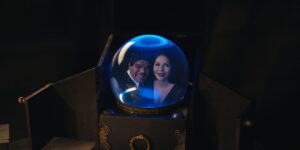 morticia and gomez smile from the inside of a crystal ball