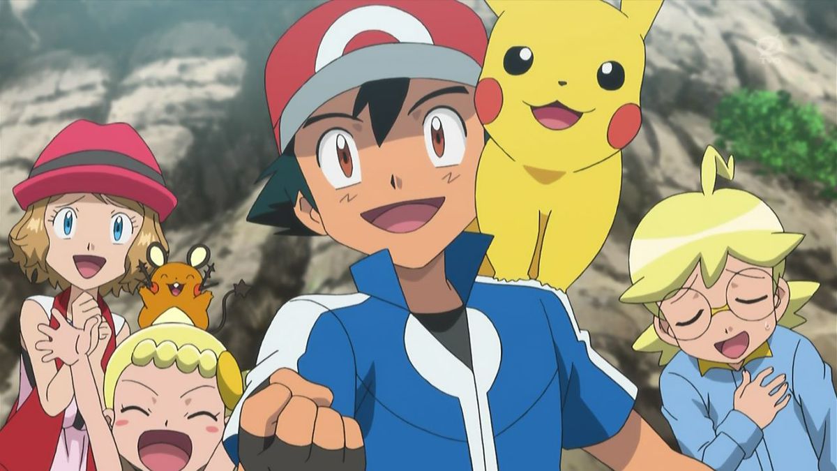 A short-haired anime girl (Serena) with a red hat, a blonde-haired girl (Bonnie) with a brown mouse-like creature on her head (Dedenne), a black-haired anime boy (Ash) with a red cap and a yellow creature on his shoulder (Pikachu), and a blond-haired boy with round glasses (Clemont) stand in front of a cliffside with green shrubs in the background.