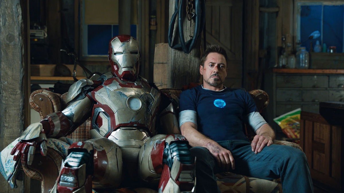 photo of tony sitting next to an iron man suit in iron man 3 christmas movie