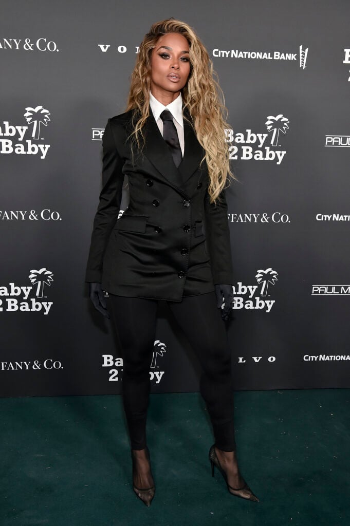 Ciara in black suit and tie against black baxkdrop
