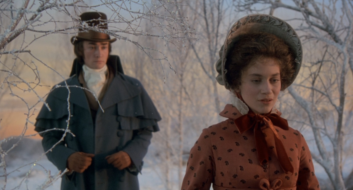 A young version of Scrooge and his fiancée Belle standing in a snowy park in Muppets Christmas Carol. 