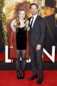 (L-R) Ruby Sweetheart Maguire in black velvet minidress and leather coat standing next to Tobey Maguire, who is wearing black suit and tie