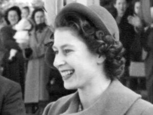 A young Queen Elizabeth smiling, in black and white.