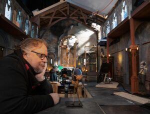 Guillermo Del Toro seems to be chatting with a little Pinocchio figure.