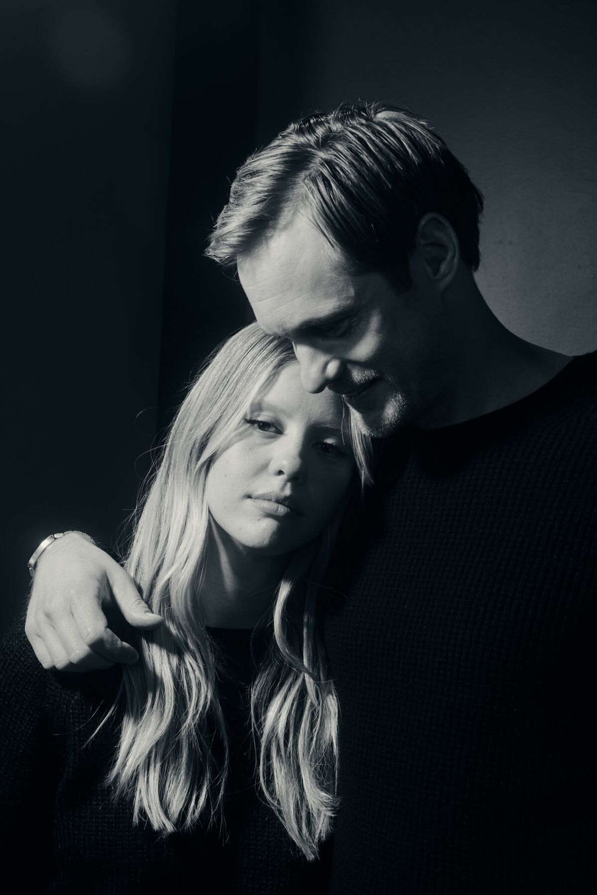 Mia Goth and Alexander Skarsgård hug in a photo studio