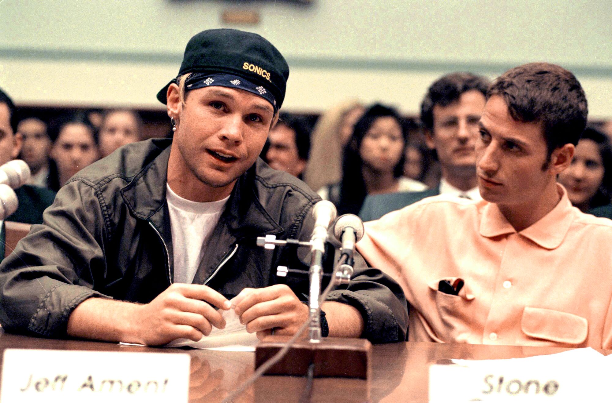 Two men at a table with a microphone, testifying to Congress