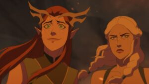 keyleth, a redhaired young woman, smiles nervously next to a pale-haired determined looking woman. they are both illuminated in a red glowing light