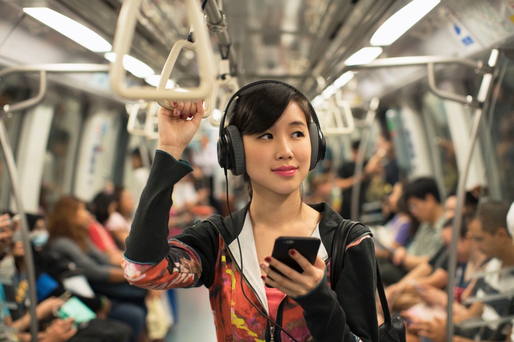 Girl listening to music on public transportation with headphones on