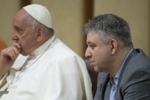 Director Evgeny Afineevsky sits next to Pope Francis at the Vatican screening of the documentary 'Freedom on Fire.'