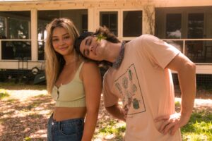 OUTER BANKS (L to R) MADELYN CLINE as SARAH CAMERON and CHASE STOKES as JOHN B on the set of OUTER BANKS Cr. JACKSON LEE DAVIS/NETFLIX  2021