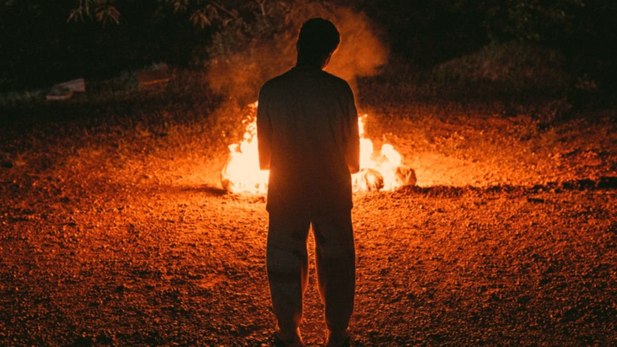 photo of a person standing in front of a fire in janine nabers series swarm