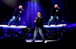 Billy Joel performs with images of him flanking him.