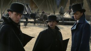 Kaz, Inej, and Jesper in coats and hats in Shadow and Bone