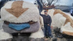 John Marks stands beside his handcrafted life-size Appa from Avatar: The Last Airbender
