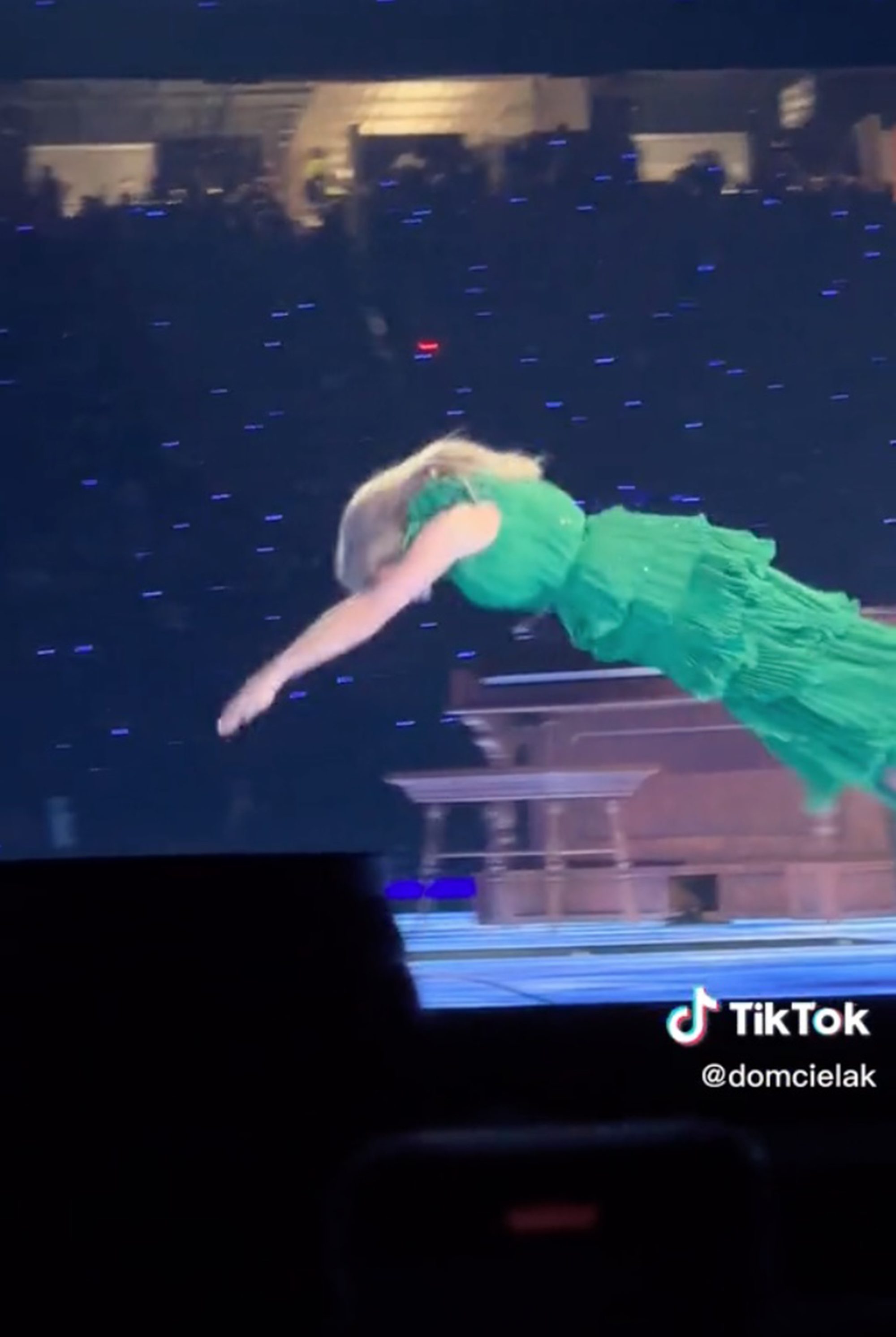 Taylor Swift diving into a stage trapdoor on her Eras Tour.