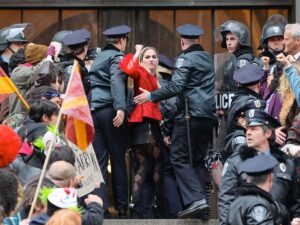 Lady Gaga is seen at movie set of the ‘Joker: Folie a Deux’ on March 25, 2023 in New York City, throwing her fist up as movie cops haul her into court and protesters cheer her name