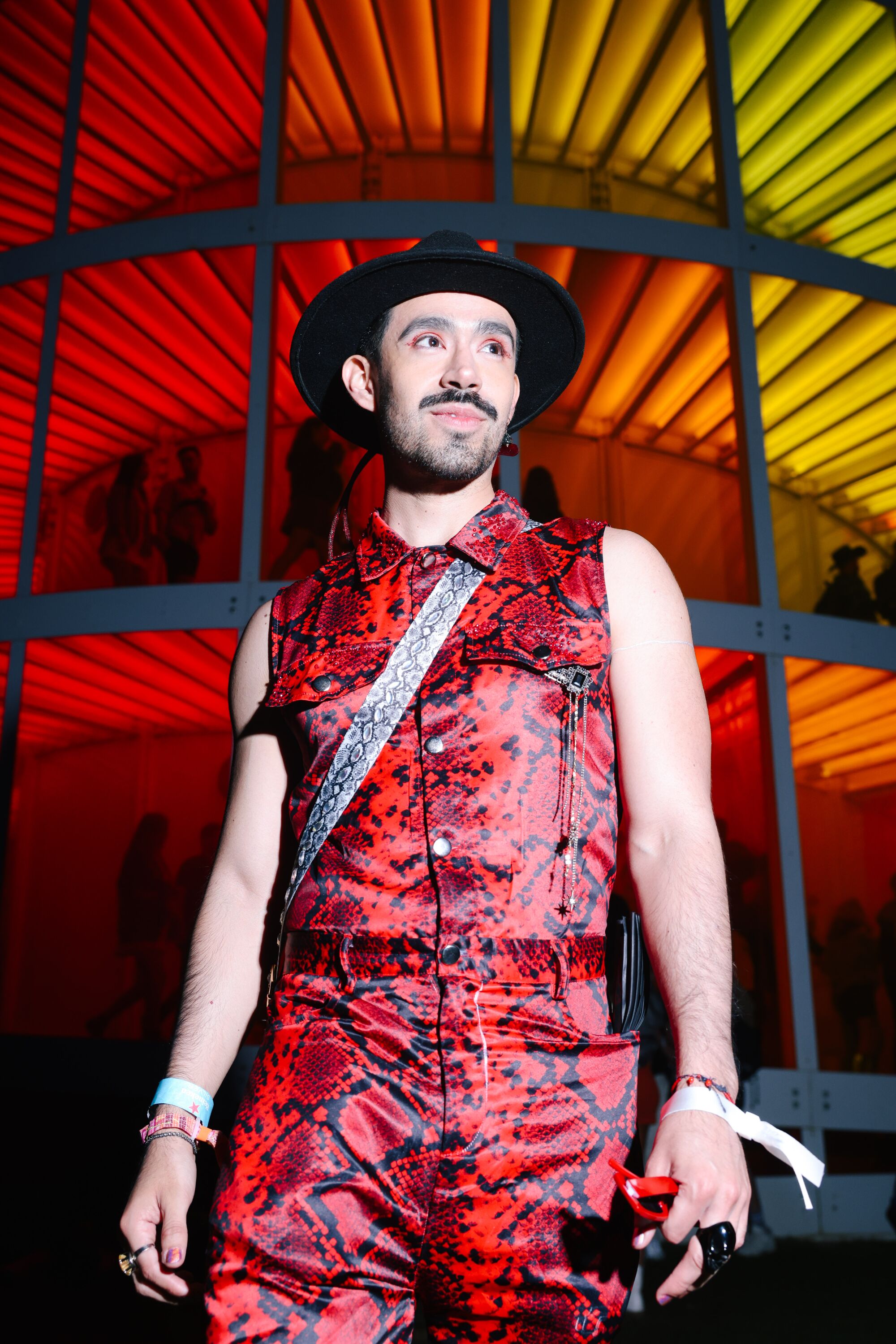 A Coachella attendee in a red snakeskin jumpsuit.