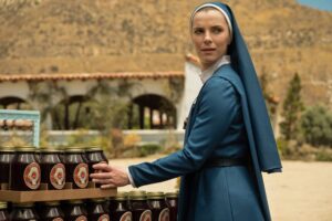 Betty Gilpin as Sister Simone holding a jar of jam in Mrs. Davis.