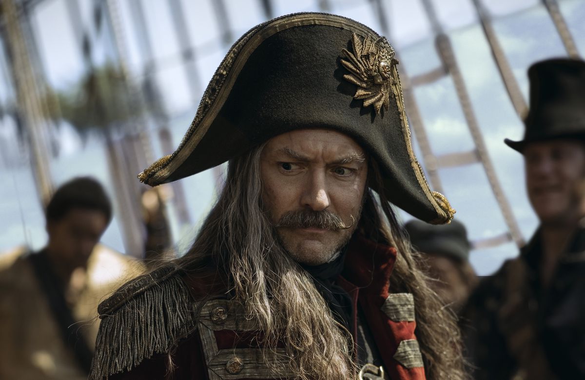Jude Law as Captain Hook in Peter Pan &amp; Wendy, in a smirking closeup on his ship