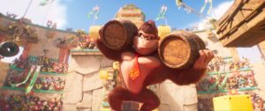 Donkey Kong carries two big barrels on his shoulders in a stadium full of apes in The Super Mario Bros. Movie