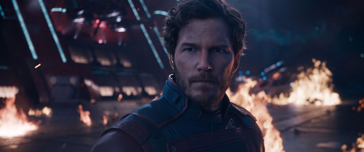 Peter Quill/Star-Lord (Chris Pratt) looks stern on the flaming deck of a spaceship in Guardians of the Galaxy Vol. 3. 