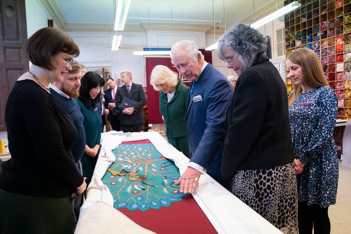 King Charles III looks at the needlework on part of the anointing screen during his visit to the Royal School of Needlework at Hampton Court Palace in London on March 21.