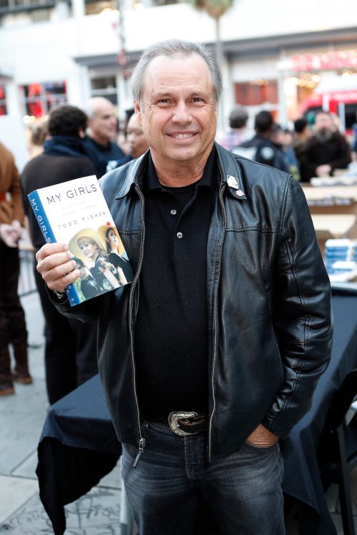 Todd Fisher with his book at opening night celebrations of 